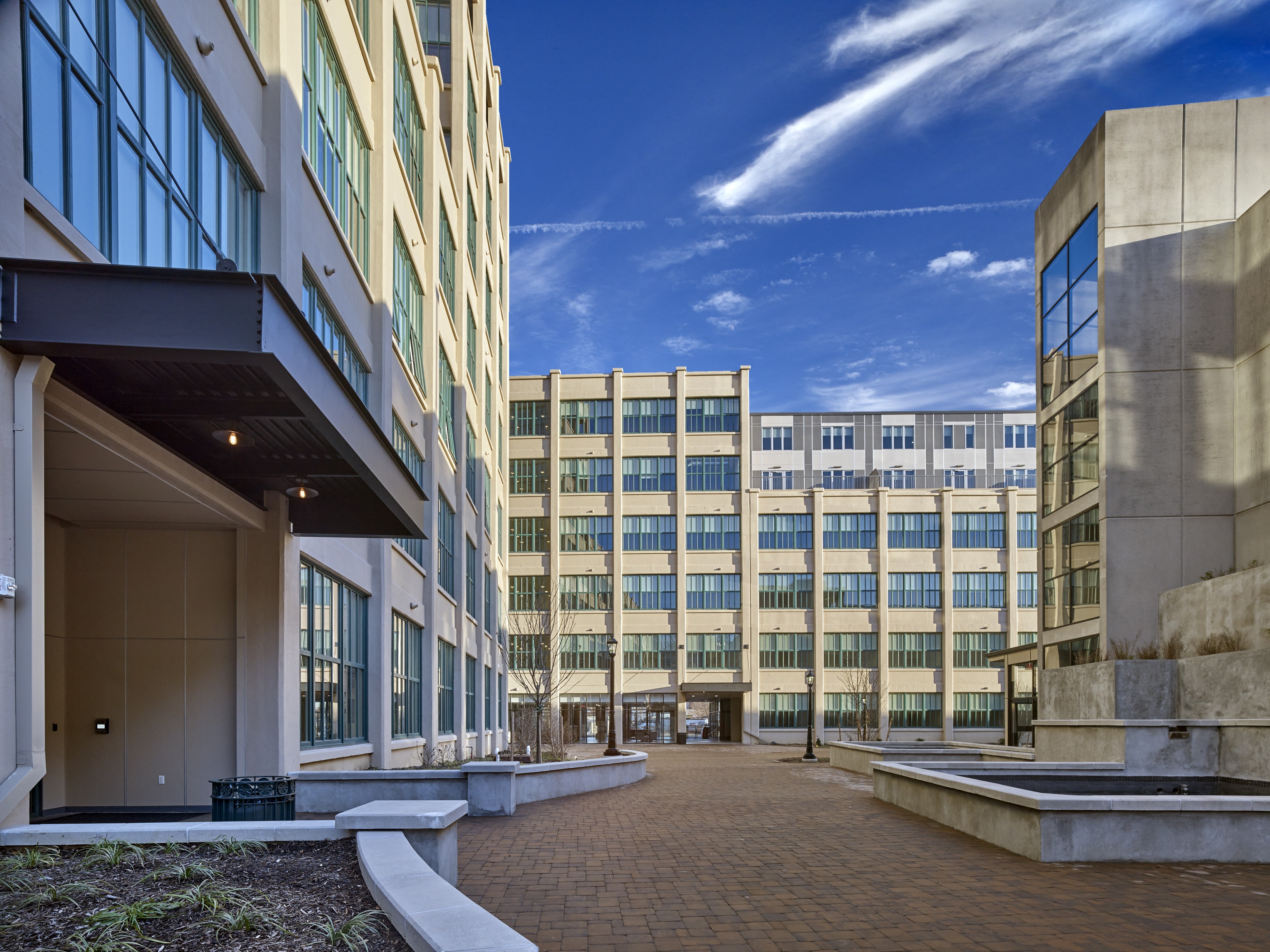 a courtyard between two buildings with a blue sky in the background